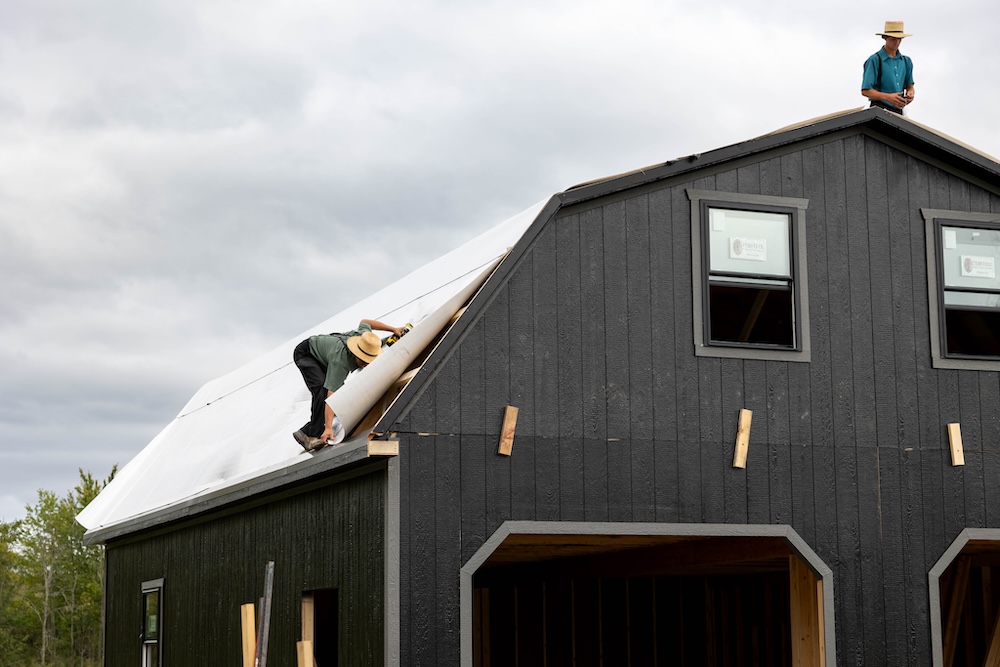 two men working on two story garage roof